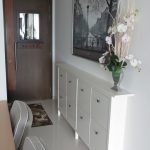 Picture of a narrow hallway cabinet of an open floor plan house interior design inspiration in white painted wooden narrow hallway cabinet design with flower decoration 888x1184